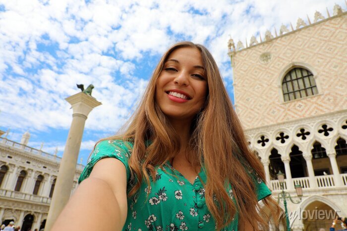 files/mulher-bonita-feliz-que-toma-a-foto-do-selfie-em-veneza-com-as-nuvens-brancas-no-ceu-menina-do-turista-que-sorri-na-camera-no-quadrado-de-st-mark-em-veneza-italia-700-127270828_ce466aa7-bade-43fc-99ed-56466ebd561e.jpg